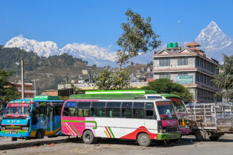 Local bus traveling from Pokhara to Jhinu Danda along a scenic mountain road, passing terraced hills, rivers, traditional villages, and lush green landscapes in the Annapurna region.