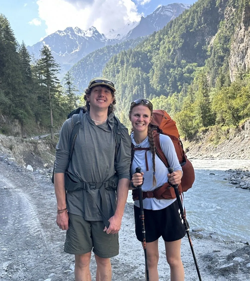 Trekker on Annapurna Circuit Trek in lower valley of Nepal walking in comfortable weather and layered trekking clothes”