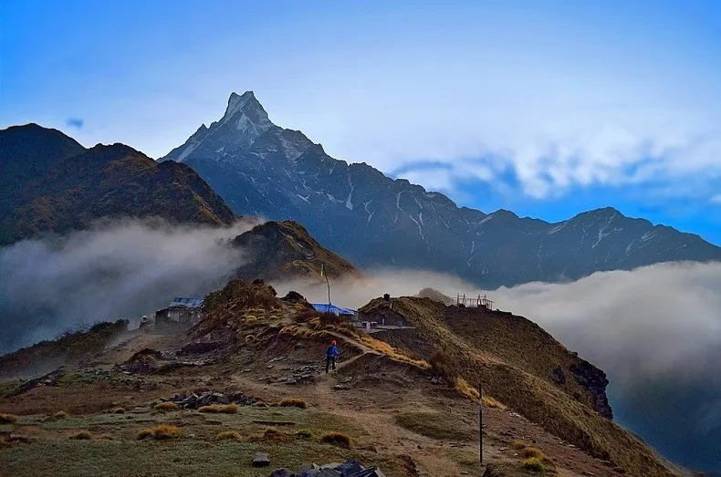Fishtail Mountain surrounded by clouds along the Mardi Himal Trek trail .