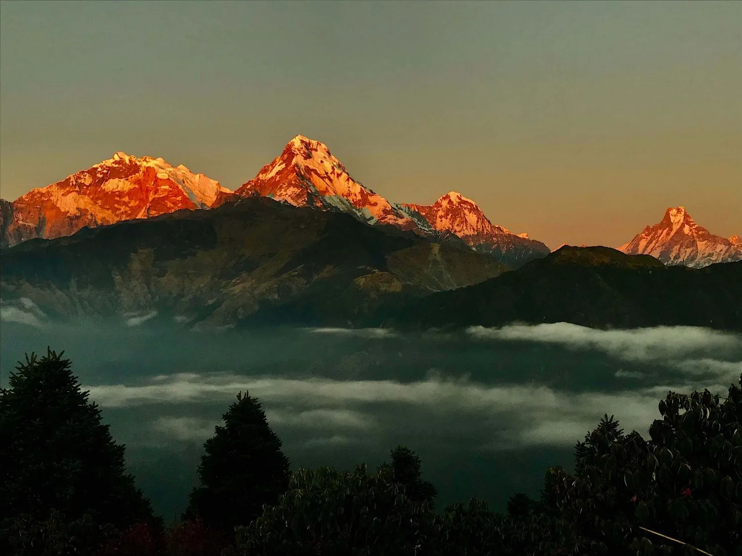 Poon Hill sunrise in September with golden views of Annapurna South, Hiunchuli, and Machhapuchhre in Nepal.