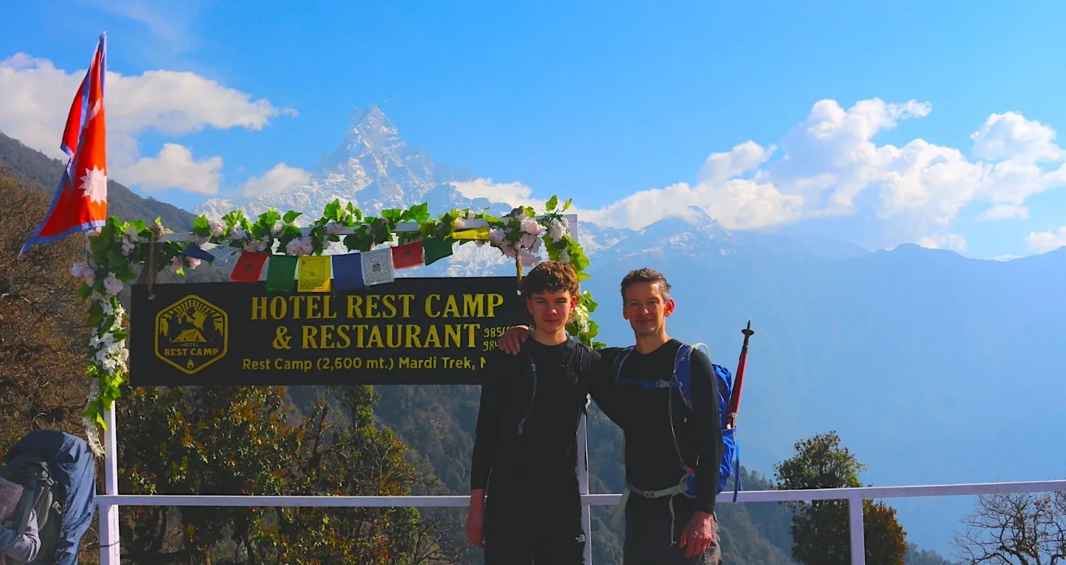 Mountain rest camp along the Mardi Himal Trek with trekkers relaxing near lodges, surrounded by panoramic Himalayan peaks and beautiful alpine scenery.