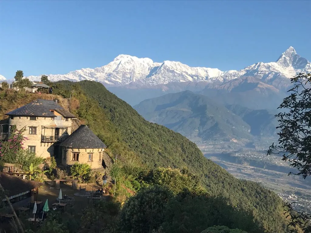 Traditional Nepali house in Sarangkot with panoramic Himalayan mountain range views.