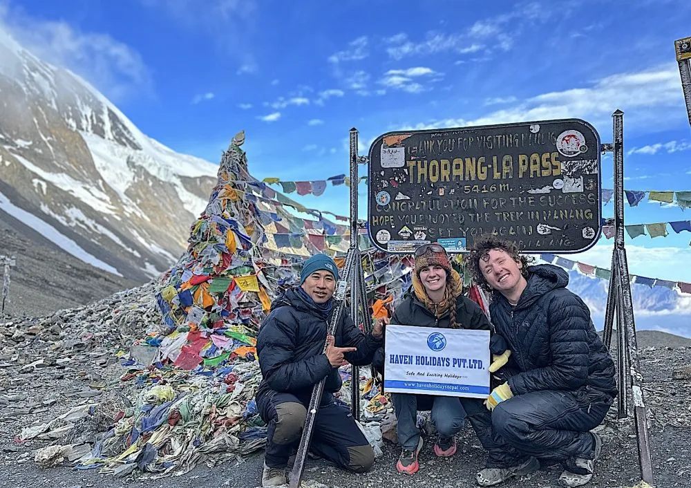 Summit of Thorong La Pass on Annapurna Circuit Trek in Nepal with prayer flags and Himalayan mountain views